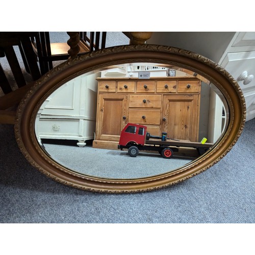 987 - Bevelled oval mirror in gold painted frame 82 x 58cm