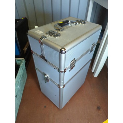 313 - Large metal make-up case on wheels with contents. 