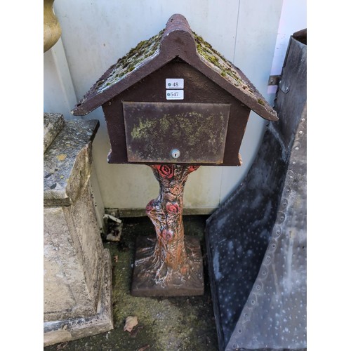 547 - Concrete formed letterbox, in the style of a traditional building atop of a tree stump. H104cm