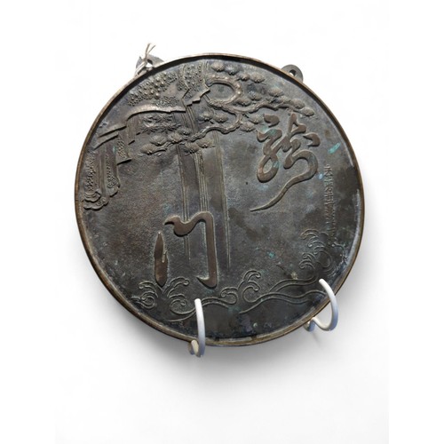 407 - Japanese bronze circular mirror decorated with pine trees and script, dia. 21.5cm