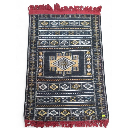 896 - Turkish style central medallion rug with tasselled ends, 74 x 110cm