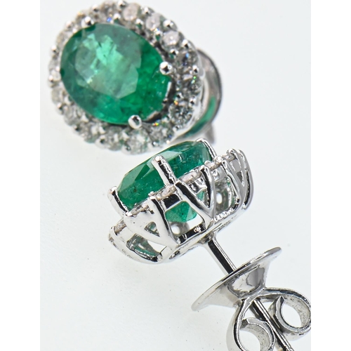 95 - Pair of 18ct white gold, emerald and diamond cluster earrings, earrings stamped 18K, length 13mm, gr... 