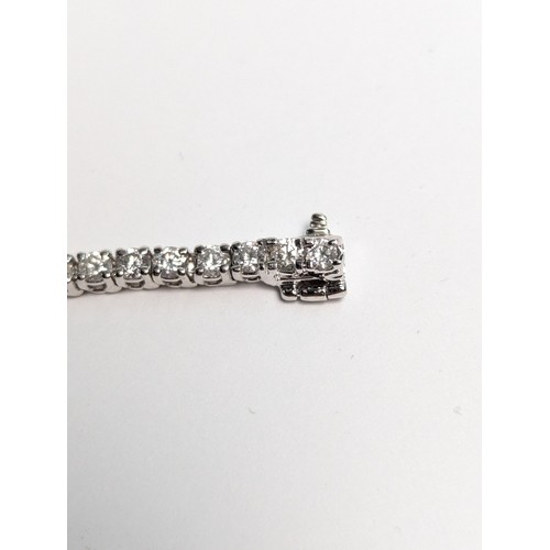 97 - 14ct white gold diamond line bracelet, comprising an articulated line of 56 claw-set brilliant-... 