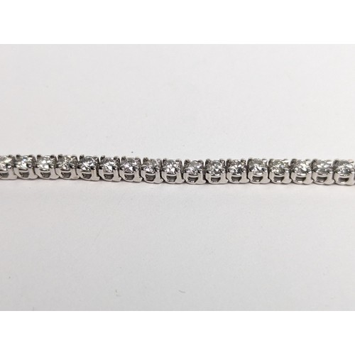 97 - 14ct white gold diamond line bracelet, comprising an articulated line of 56 claw-set brilliant-... 