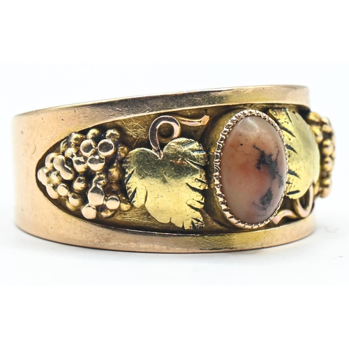 103 - 14ct bicolour gold and hardstone ring, centring a hardstone flanked by a bunch of grapes and vine le... 