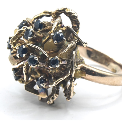 104 - 14ct gold band ring with later attached yellow metal flowerhead set with blue stones, band stamped 1... 