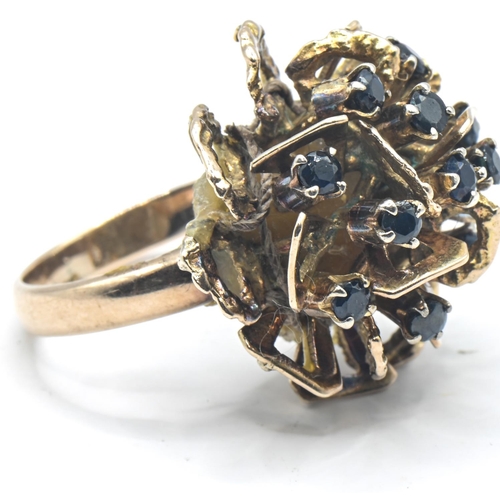 104 - 14ct gold band ring with later attached yellow metal flowerhead set with blue stones, band stamped 1... 