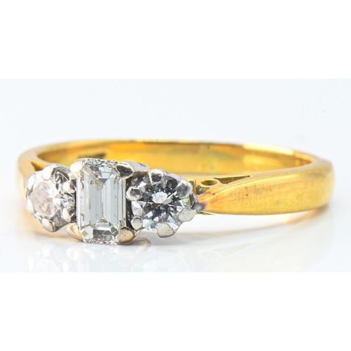 194 - 18ct gold and three diamond ring, centring an emerald-cut diamond flanked by a pair of brilliant-cut... 