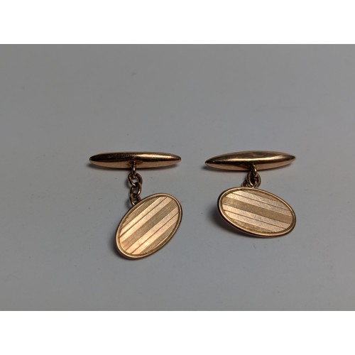 229 - Pair of 9ct rose gold cufflinks, each with one oval plaque with engine-turned decoration, plaques me... 