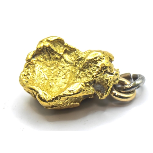 242 - Small nugget of high grade yellow metal, with base metal loop and bale, gross weight 1.96 grams