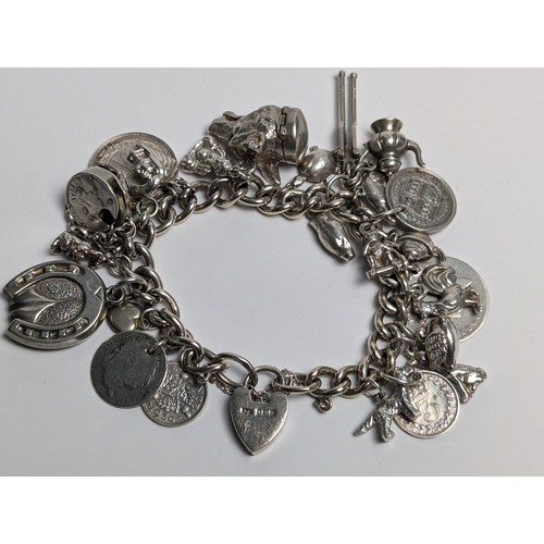 285 - Silver charm bracelet with heart-shaped padlock clasp and silver and white metal charms, gross weigh... 