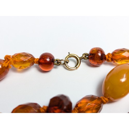 289 - Honey colour amber bead necklace with 9CT marked clasp and a pair of gilt metal mounted earrings, gr... 