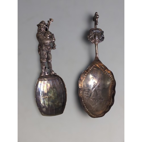 358 - Two continental export silver caddy spoons, including: one designed as a bag piper upon a barrel,&nb... 