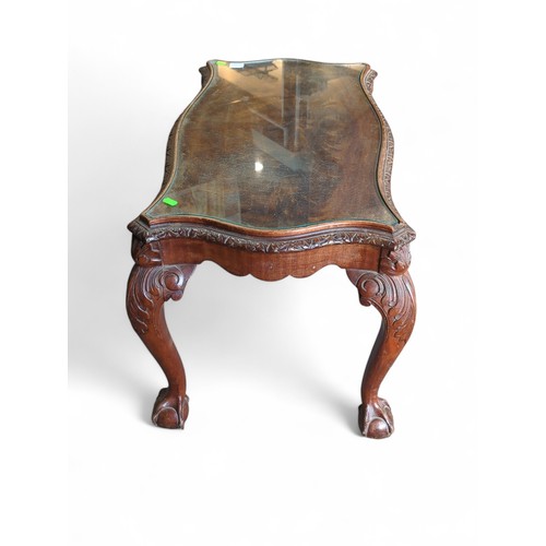 46 - Ornate carved mahogany coffee table with glass top and ball and claw feet. W45cm L85cm H48cm.