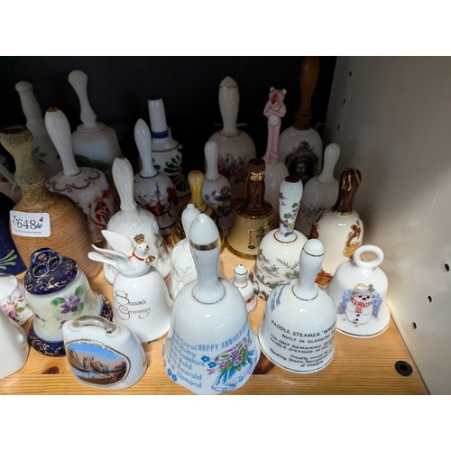 648 - Quantity of assorted ceramic and glass bells over two shelves