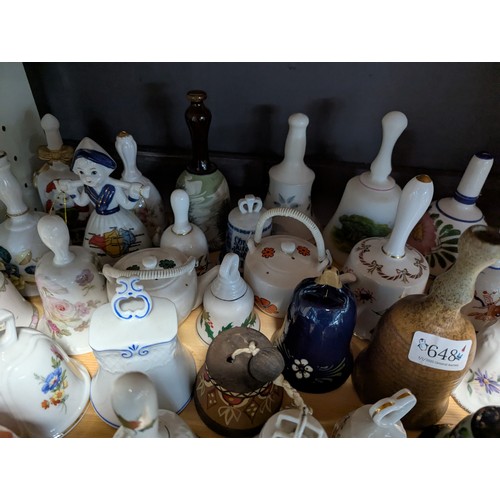 648 - Quantity of assorted ceramic and glass bells over two shelves