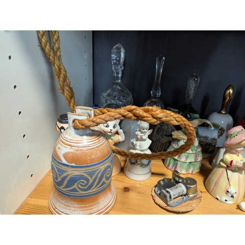 648 - Quantity of assorted ceramic and glass bells over two shelves