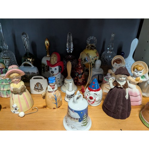 648 - Quantity of assorted ceramic and glass bells over two shelves