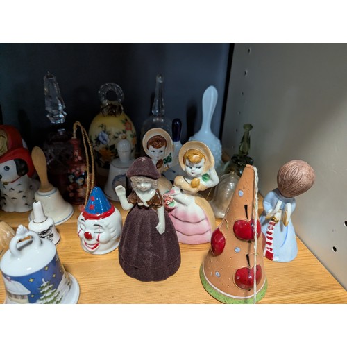 648 - Quantity of assorted ceramic and glass bells over two shelves