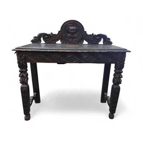 34 - Carved oak console/hallway table with carved detail, possibly Green Man. W104cm D43cm H103cm.