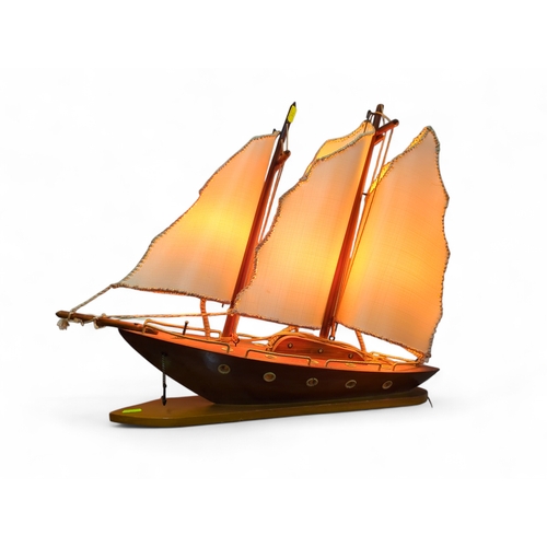 109 - Malaysian wooden boat table lamp, marked to base. 61cm by 15cm by 47cm.