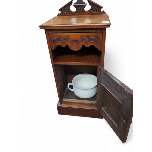 162 - A late Victorian bedside cupboard with rear gallery, carving to door front, and ceramic chamberpot. ... 