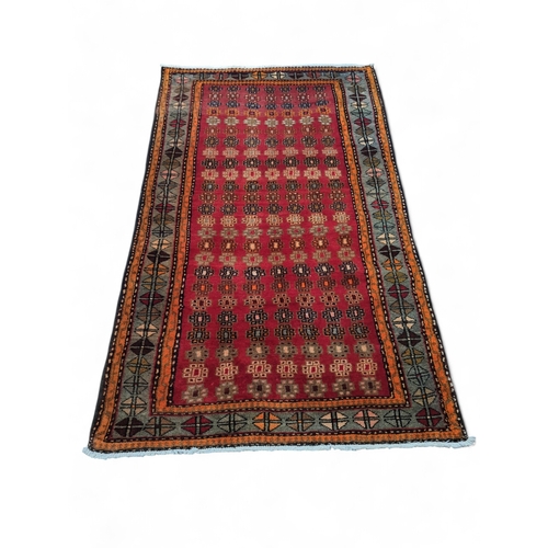 277 - Hamedan. 100 wool pile geometric rug in reds, orange, greys 116cm by 203cm