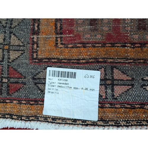 277 - Hamedan. 100 wool pile geometric rug in reds, orange, greys 116cm by 203cm