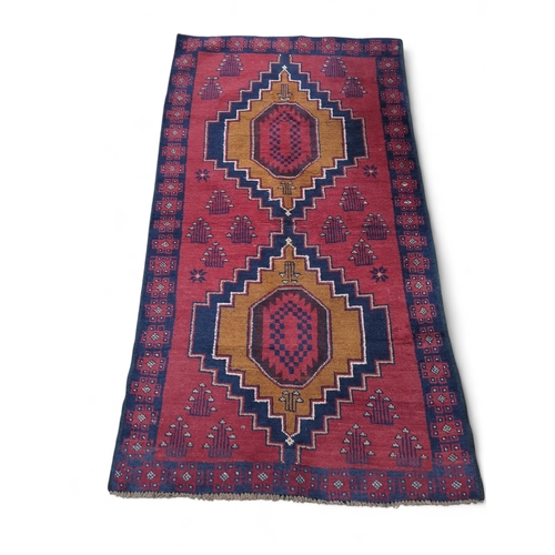 278 - Persian style rug in reds. Orange. Blue. 110cm by 194cm