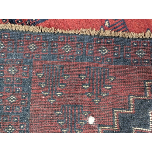 278 - Persian style rug in reds. Orange. Blue. 110cm by 194cm