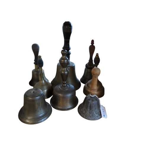 343 - Eight hand bells, six with turned wooden handles, one with engraved Asian decoration to waist and me... 