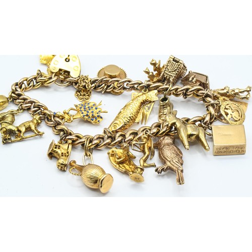 119 - Yellow metal charm bracelet with heart-shaped padlock clasp suspending 26 various 9ct gold and yello... 