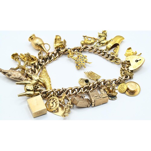 119 - Yellow metal charm bracelet with heart-shaped padlock clasp suspending 26 various 9ct gold and yello... 