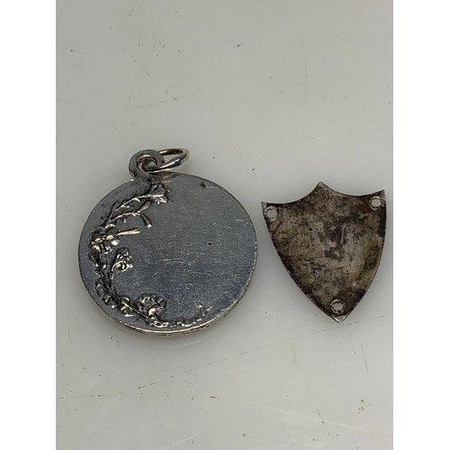 289 - Two hallmarked silver fob medals, a hallmarked shield-shaped plaque and an untested white metal meda... 