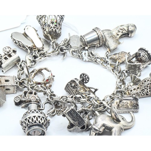 176 - Silver charm bracelet with various silver and white metal charms, gross weight 100.41 grams