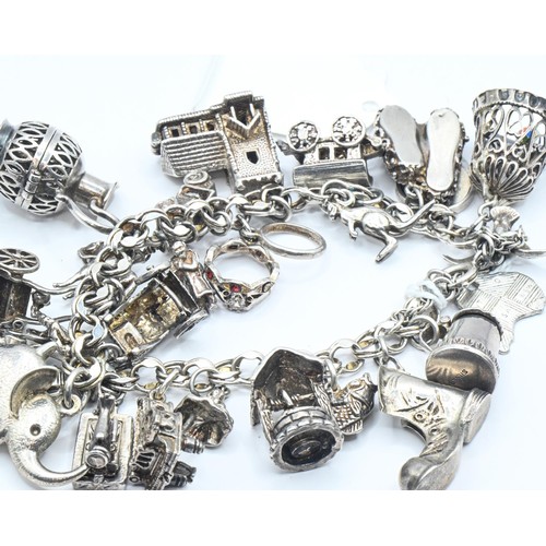 176 - Silver charm bracelet with various silver and white metal charms, gross weight 100.41 grams