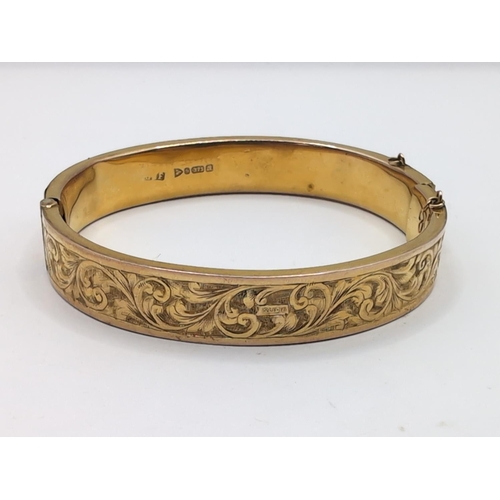 39 - 9ct gold hinged bracelet, hallmarked,&nbsp;with a foliate scroll pattern to one side, inner width 58... 
