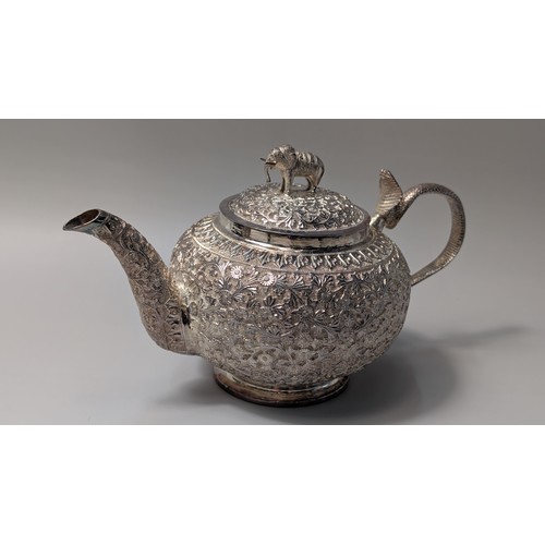 327 - Indian white metal three-piece tea set, the globular bodies with foliate decoration, cobra handles a... 