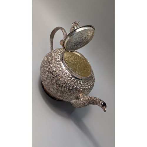327 - Indian white metal three-piece tea set, the globular bodies with foliate decoration, cobra handles a... 
