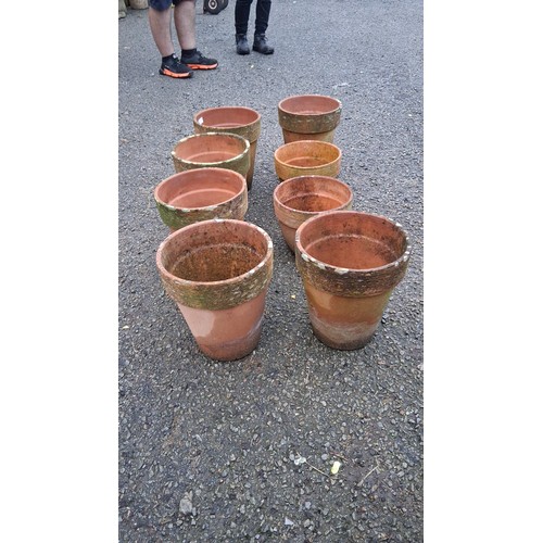 27 - Set of 8 terracotta plant pots of tapering cylindrical form, each with a thickened rim and pronounce... 