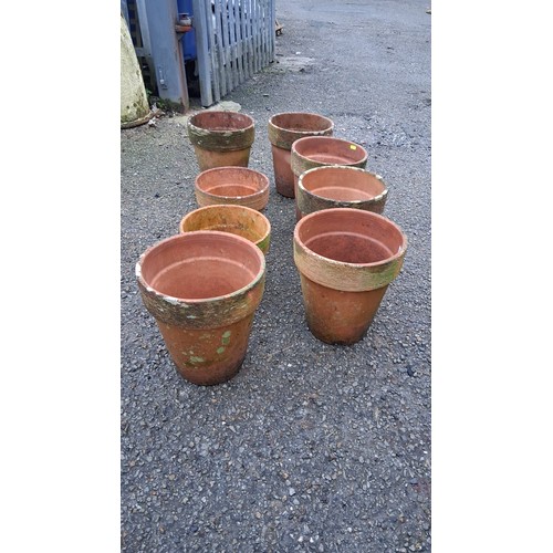 27 - Set of 8 terracotta plant pots of tapering cylindrical form, each with a thickened rim and pronounce... 
