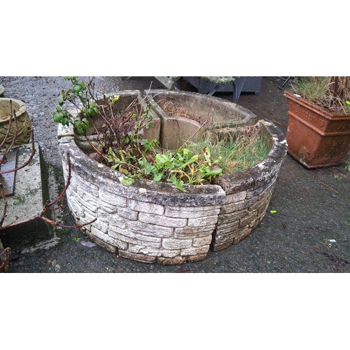 107 - A circular cast stone garden planter, of faux-stone blockwork exterior and four-compartment interior... 