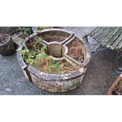 107 - A circular cast stone garden planter, of faux-stone blockwork exterior and four-compartment interior... 