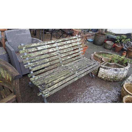 109 - A garden bench with slatted timber seat and back on a painted metal frame, with scroll-ended legs an... 
