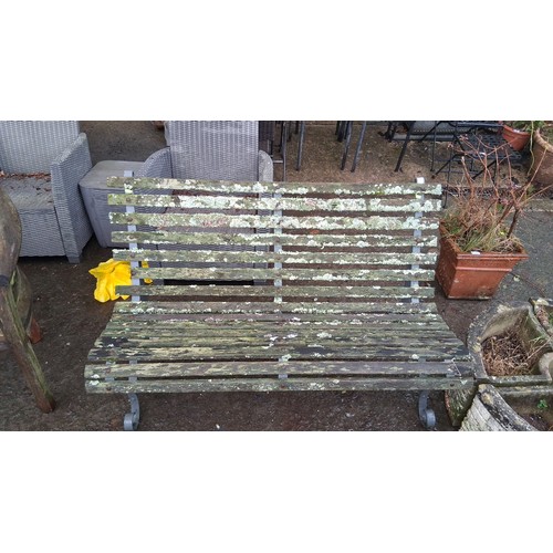 109 - A garden bench with slatted timber seat and back on a painted metal frame, with scroll-ended legs an... 