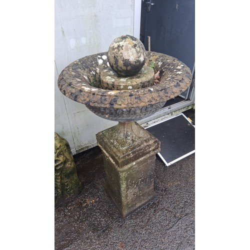 125 - A cast stone garden fountain, the circular basin with foliate moulding and rope-twist rim, on a squa... 