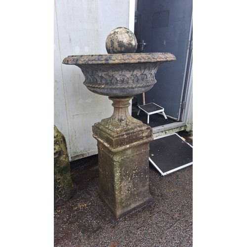 125 - A cast stone garden fountain, the circular basin with foliate moulding and rope-twist rim, on a squa... 