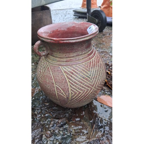 79 - A terracotta amphora-form vessel with wide flared rim and twin loop handles, the globular body incis... 