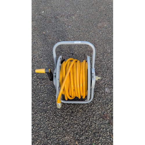 186 - A Titan hand-crank hose reel on tubular metal frame, fitted with a yellow garden hose and quick-conn... 