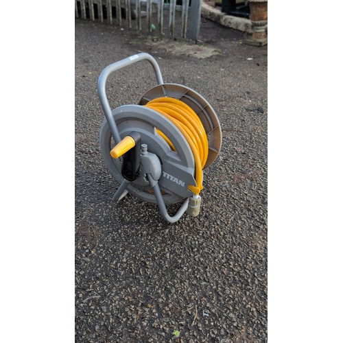 186 - A Titan hand-crank hose reel on tubular metal frame, fitted with a yellow garden hose and quick-conn... 